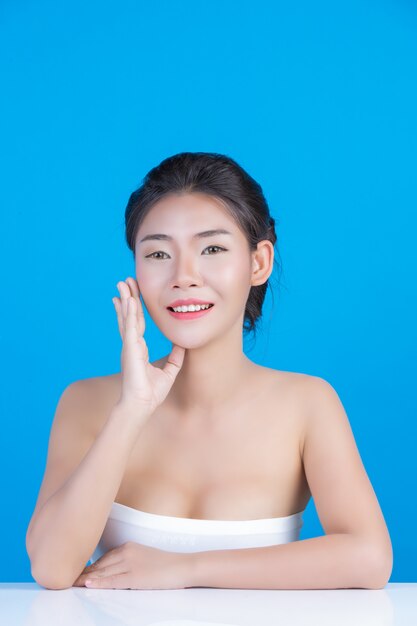 The beauty of women with perfect skin health images Touching her face and smiling like a spa to pamper her skin Blue 