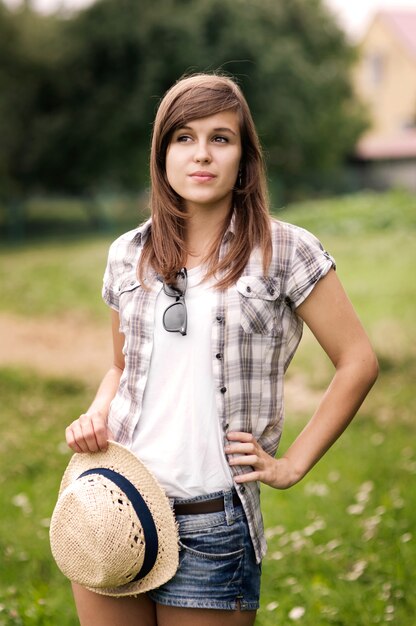 Beauty young woman with fedora hat in hand