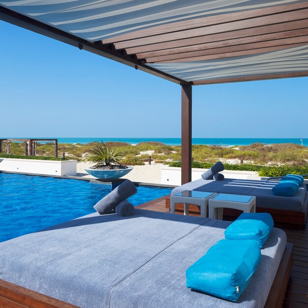 Bed near swimming pool and beach.