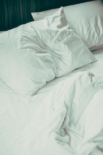 Bed with crumpled sheets and two pillows