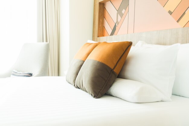 회색과 주황색 쿠션이있는 침대