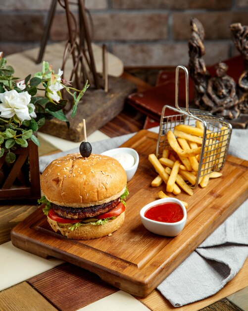 Beef burger served with french fries ketchup and mayonnaise
