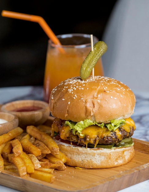 Beef burger topped with cornichon, served with fries