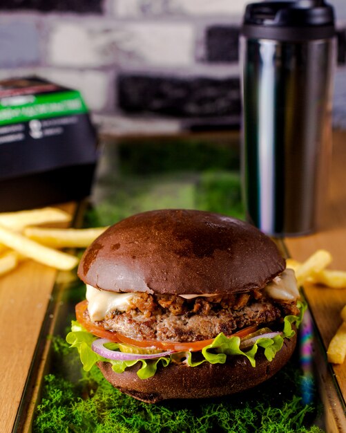 Beef burger with brown bread lettuce tomato onion and pickled cucumber