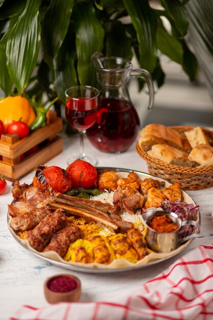 Beef, chicken kebab, bbq with roasted, grilled potatoes, tomatoes and rice   