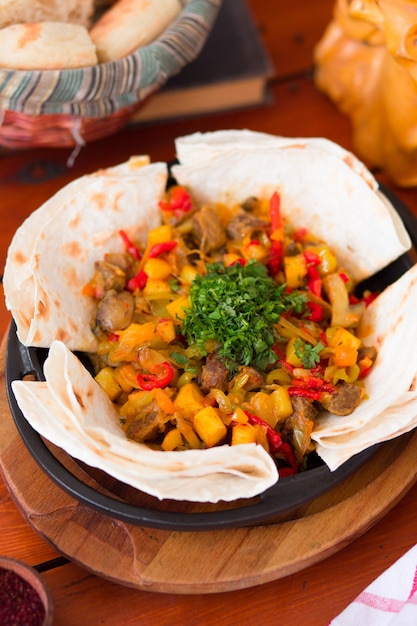 Free photo beef meat stew with potatoes and chopped vegetables served with lavash .