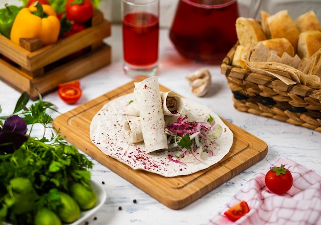 Beef meat traditional turkish kebap durum lavash served on a wooden board with vegetables wine and bread 