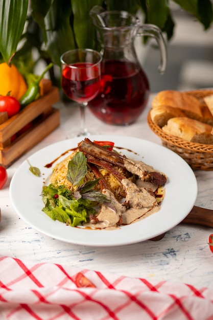 Beef rack in cream butter sauce served with rice garnish and green salad.