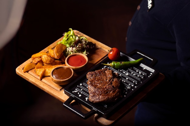 Bistecca di manzo su mini padella con patate fritte, insalata fresca