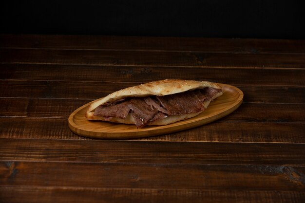 кусочки говяжьего стейка в хлебе на деревянной тарелке
