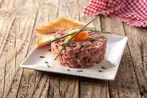 Foto gratuita bistecca di manzo alla tartara su tavola di legno