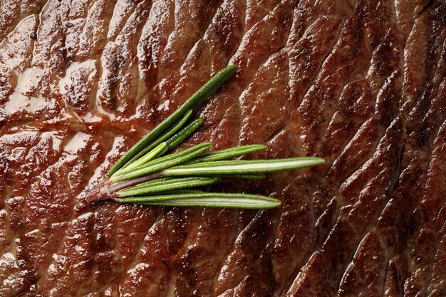 Beef steak with rosemary on whole background, close up