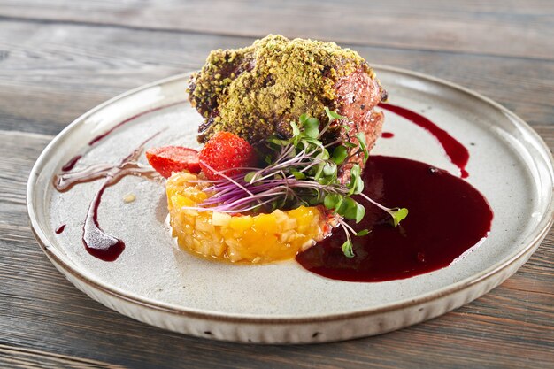 Beef with pistachio topping served with fruits and berries