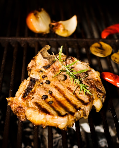 Beefsteak with spices and vegetables on grill