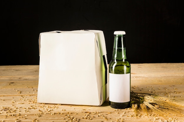 Пивная бутылка картонная коробка на деревянном фоне