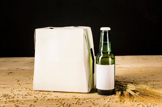 木製の背景にビール瓶のカートンボックス