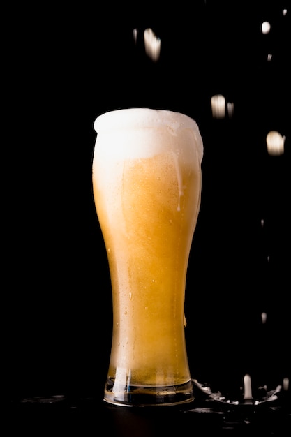 Foto gratuita bicchiere di birra davanti a sfondo nero