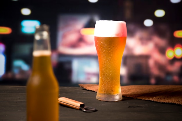 Beer glass with blurred bottle