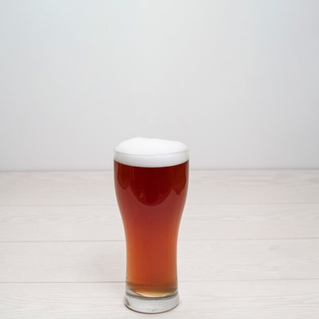 Beer glass with foam on table