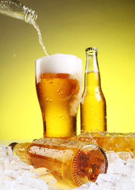 Free Stock Photo of Cold bottles of beer in ice on yellow background