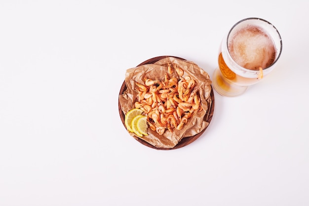 Beer and prawns on white.