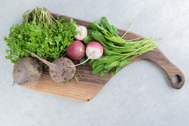 Beetroot , radish and parsley on board , on the marble background.