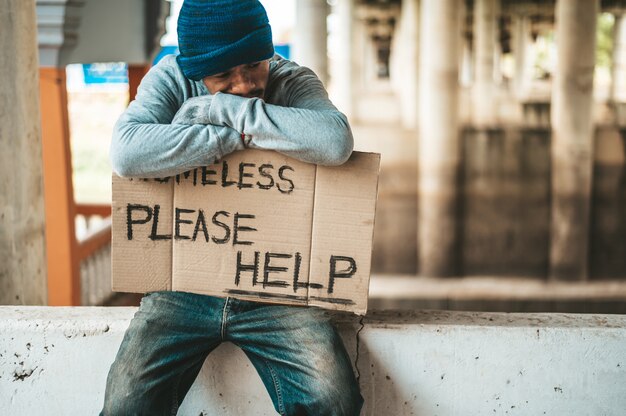 거지는 노숙자와 함께 장벽에 앉아 메시지를 도와주세요.
