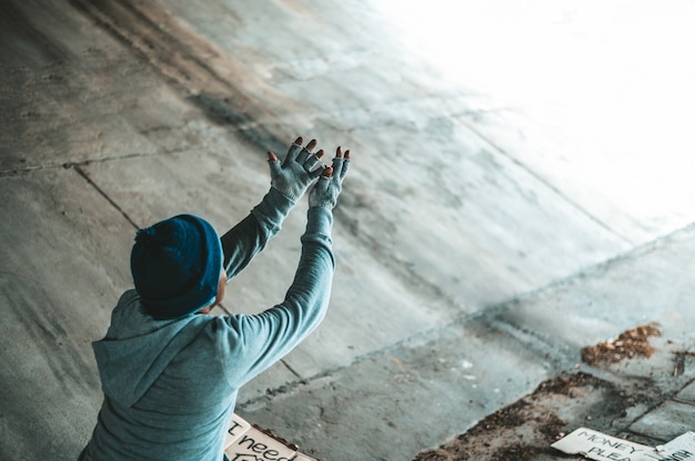 Beggars sitting under the bridge with both hands out in front