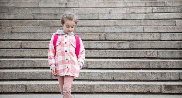 The beginning of lessons and the first day of autumn. A sweet girl standing in front of staris