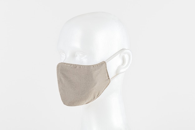 Beige fabric face mask on a dummy head