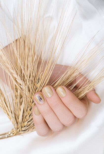 Beige nail design. Female hand with glitter manicure.