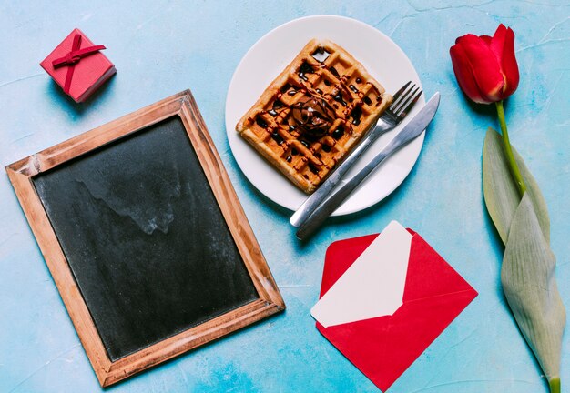 Belgian waffle on plate with blank chalkboard