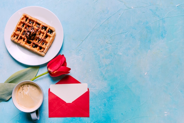 Belgian waffle on plate with red tulip