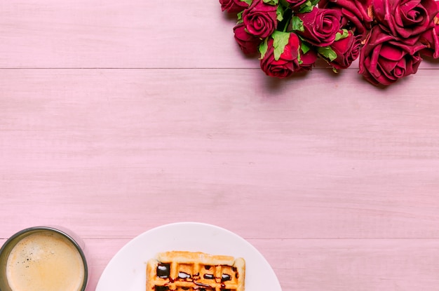 Free photo belgian waffle with roses bouquet and coffee