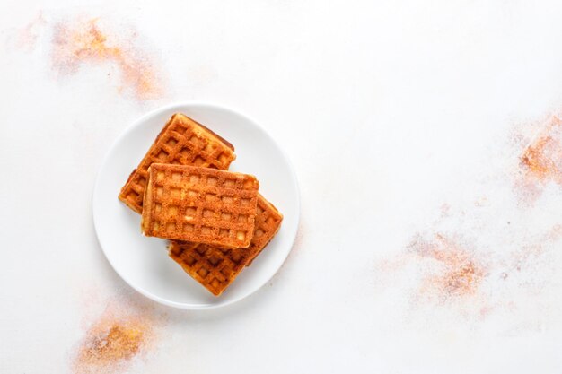 Belgian waffles with cream and fresh raspberries.