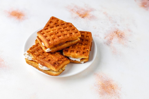 Foto gratuita waffle belgi con panna e lamponi freschi.