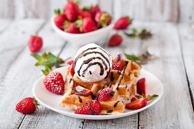 Belgium waffles with strawberries and ice cream  on white plate