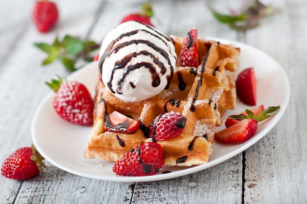 Belgium waffles with strawberries and ice cream  on white plate