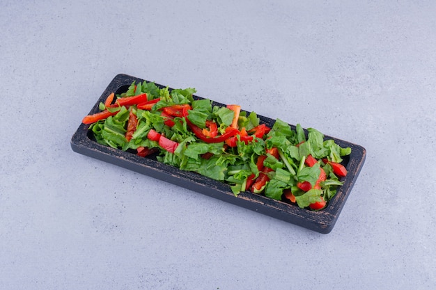 Bell pepper and lettuce salad in a small tray on marble background. High quality photo