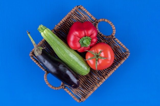 Bell pepper, tomato, eggplant and zucchini in wooden basket