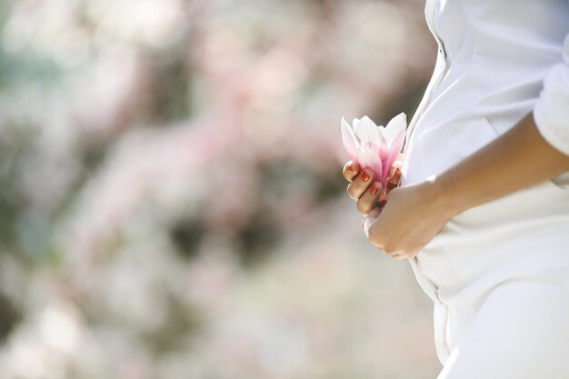Belly of a pregnant woman and a flower
