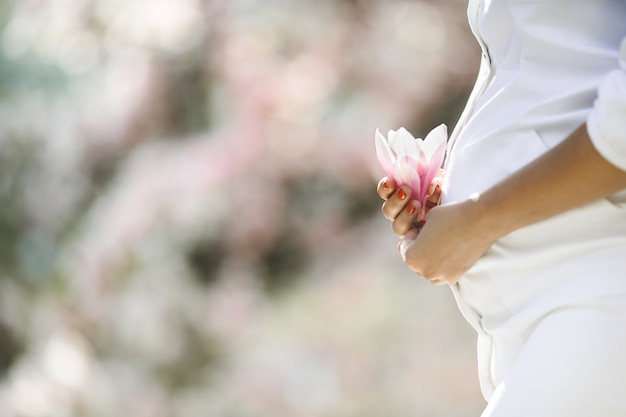 Живот беременной женщины и цветок