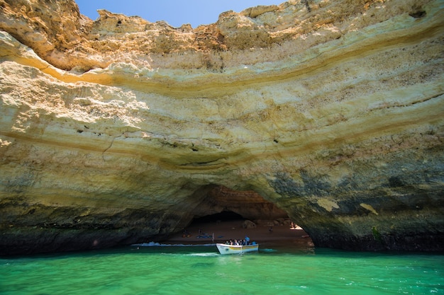 Бесплатное фото Прогулка на лодке по пещере бенагил в альгар-де-бенагил, пещере, включенной в 10 лучших пещер мира. побережье алгарве около лагоа, португалия. туристы посещают популярную достопримечательность