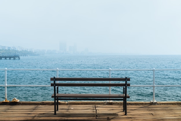 Bench on a pier with a view on morning haze over Limassol harbour, Cyprus.