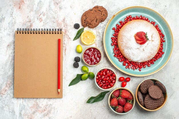 berries and cookies the appetizing cake with berries jam cookies notebook pencil