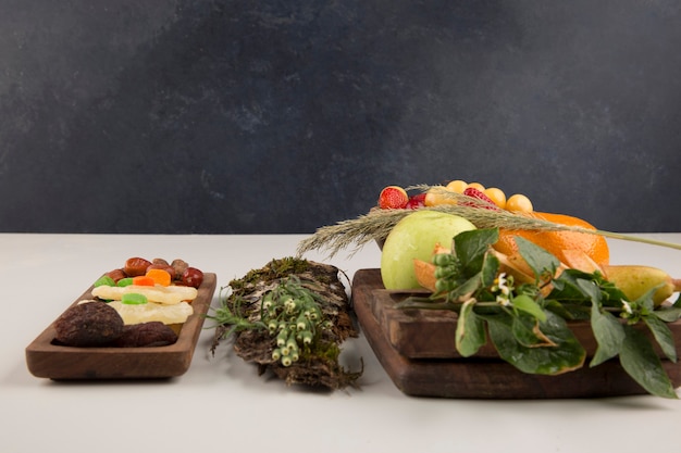 Berries, fruit mix and herbs in a wooden platter isolated on white space