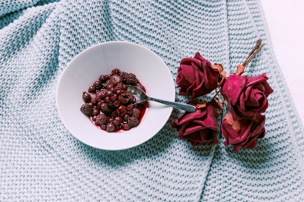 Berries on plate with dry roses 