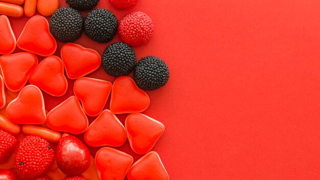 빨간색 배경에 베리 과일과 심장 모양 사탕