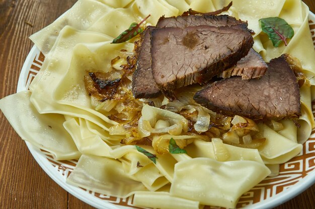 ベシバルマック​、​茹でた​肉​を​ナイフ​で​細かく​刻み​、​茹でた​麺​と​混ぜ合わせます​。​通常​、​キルギス​料理​、​伝統的​な​盛り合わせ​料理​、​トップビュー​。