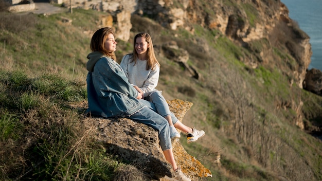 Best female friends sitting on a hill